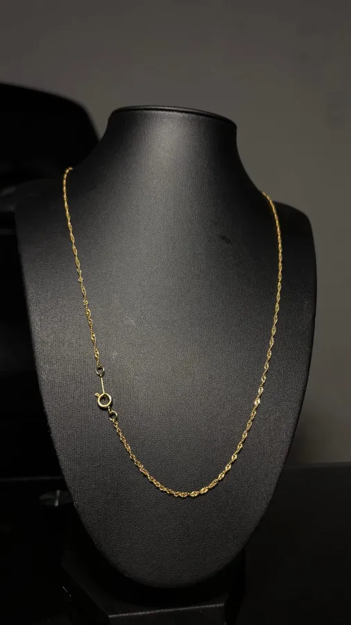 Cadena Singapur bañada en oro sobre un busto negro