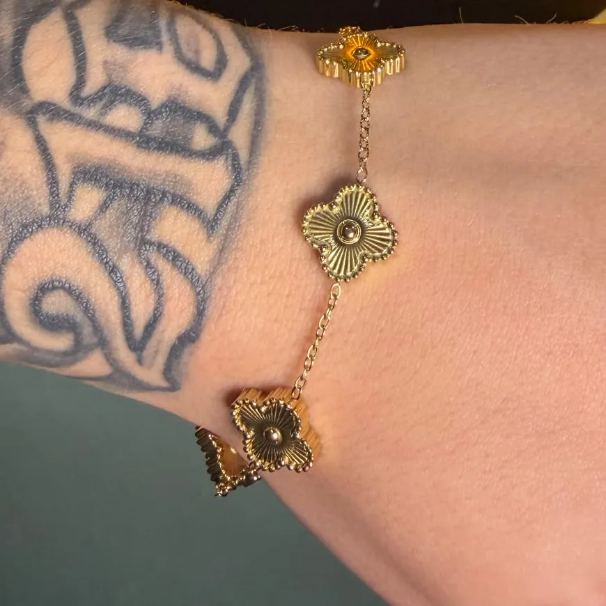 Pulsera de tréboles dorada en la muñeca
